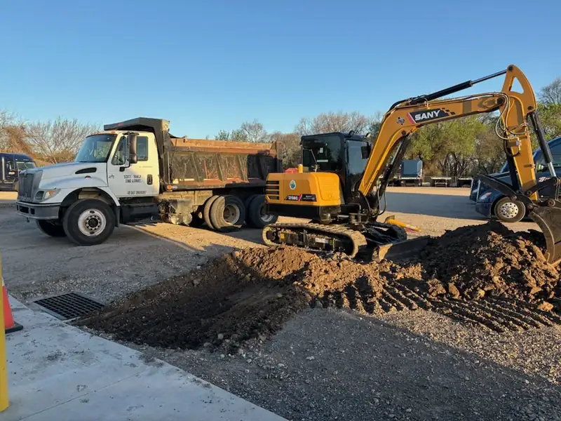 Dump truck and SANY excavator digging a drainage trench