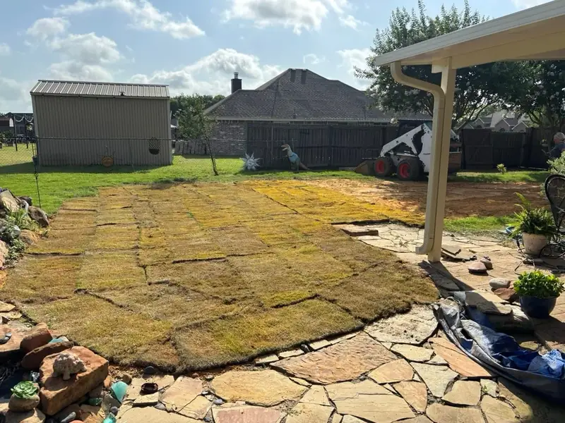 Finished koi pond area with fresh sod laid next to the flagstone patio