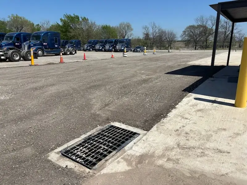 Finished commercial truck yard with new drainage grate and crushed base